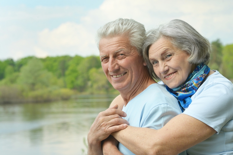 Senior couple smiling and hugging.