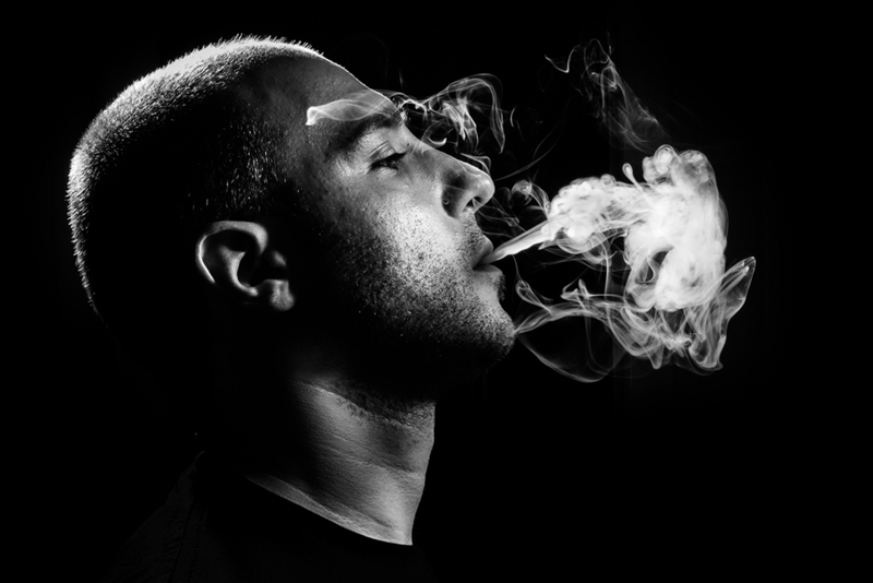 Man blowing smoke puff.