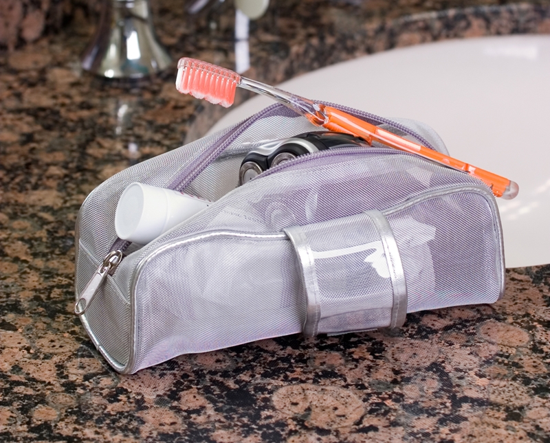 Toothbrush sticking out of toiletry bag by sink.