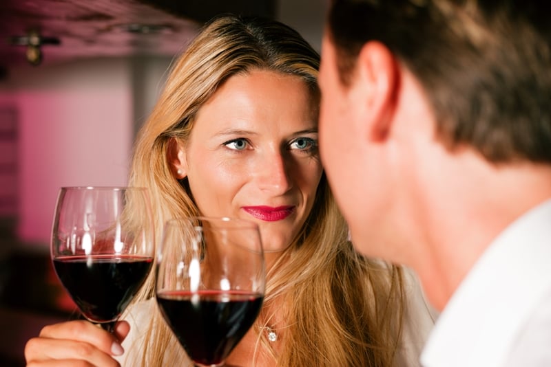 Couple on date drinking red wine.