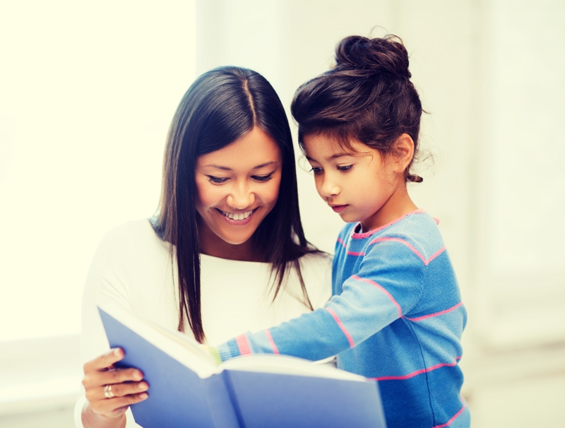 Mom and daughter reading book.