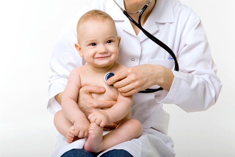 Baby smiling in doctor's lap.