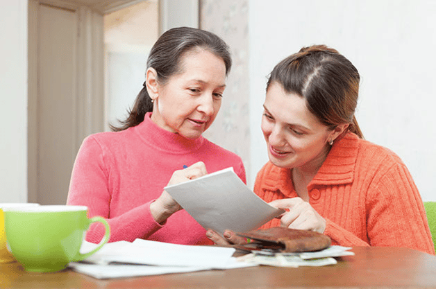 Senior Dental Health - Adult mother and daughter reviewing billing statement