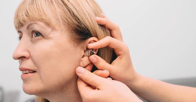 Senior Woman Gets Assistance With Hearing Aid