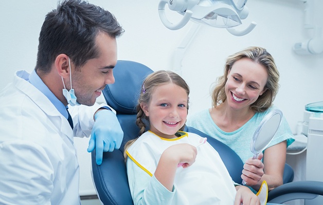 Dentist examining girls teeth