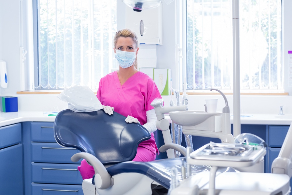 Dental health quiz - Female dentist wearing mask in dental exam room.