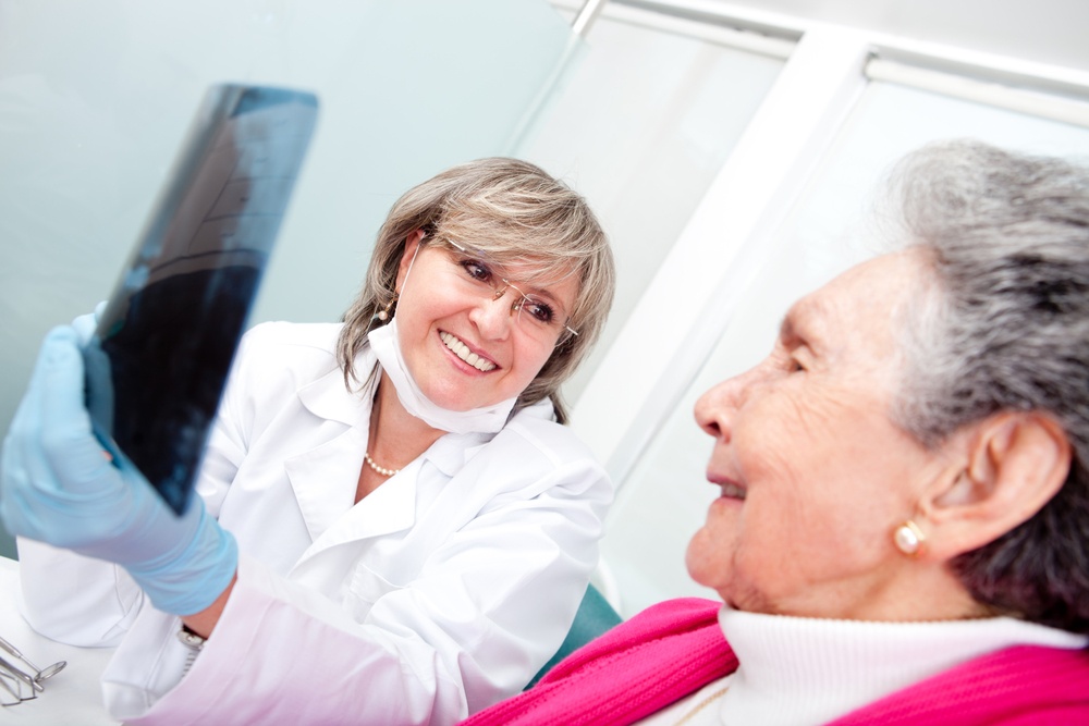 Dentist with an elder female patient looking at an x-ray