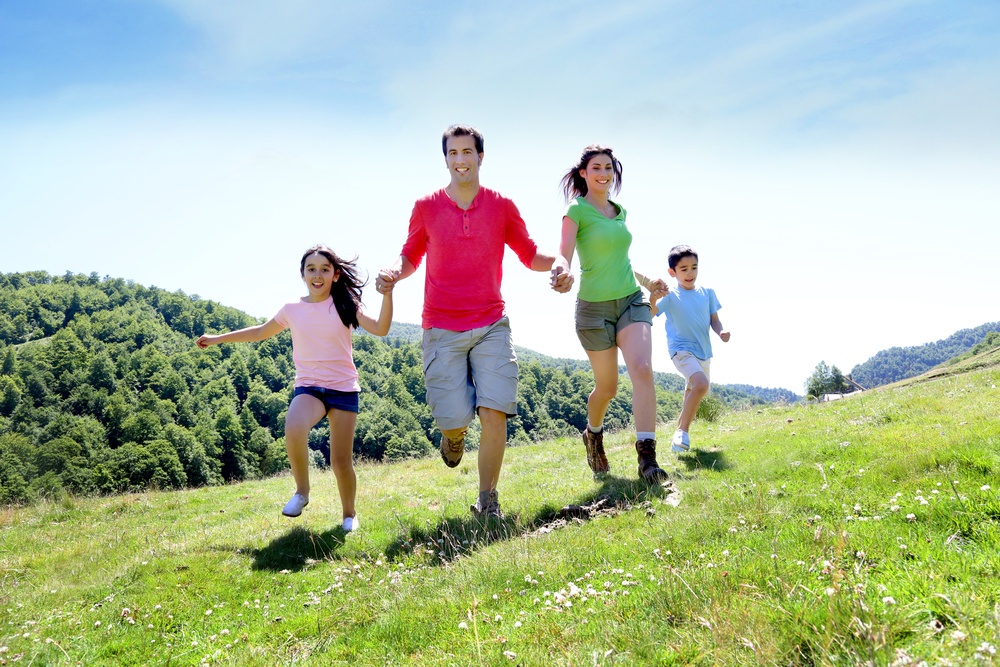 Happy family enjoying and running together in the mountains