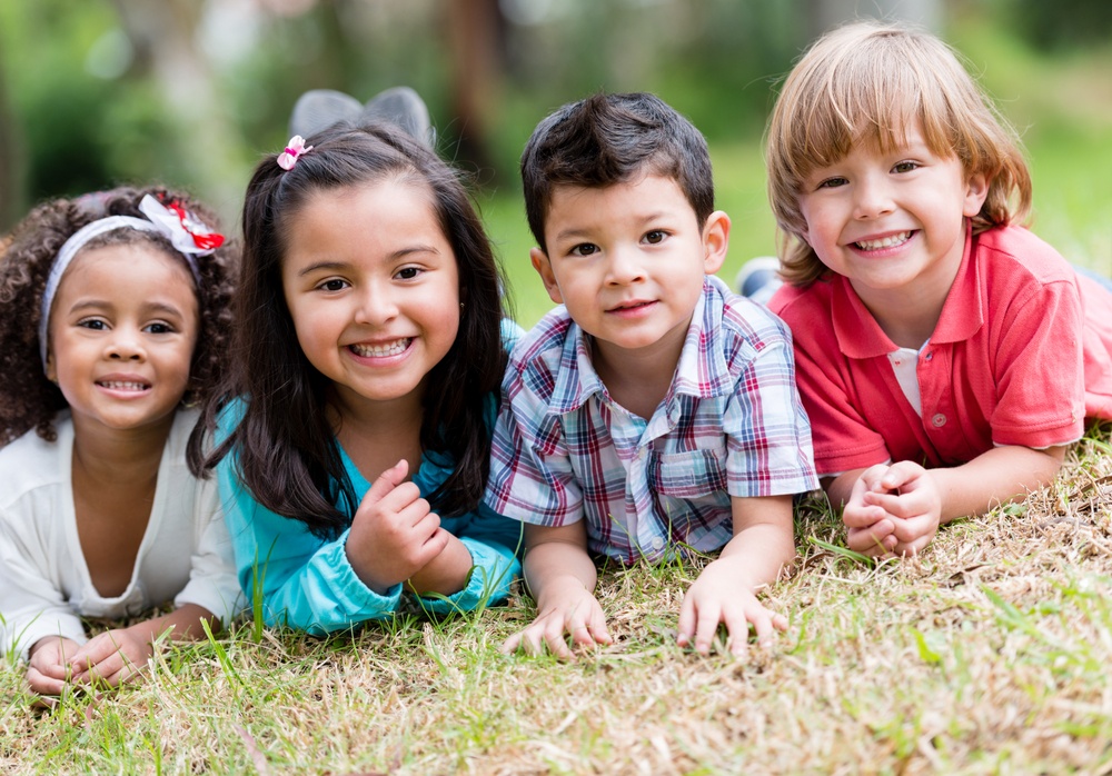 Happy group of kids playing and smiling at the park