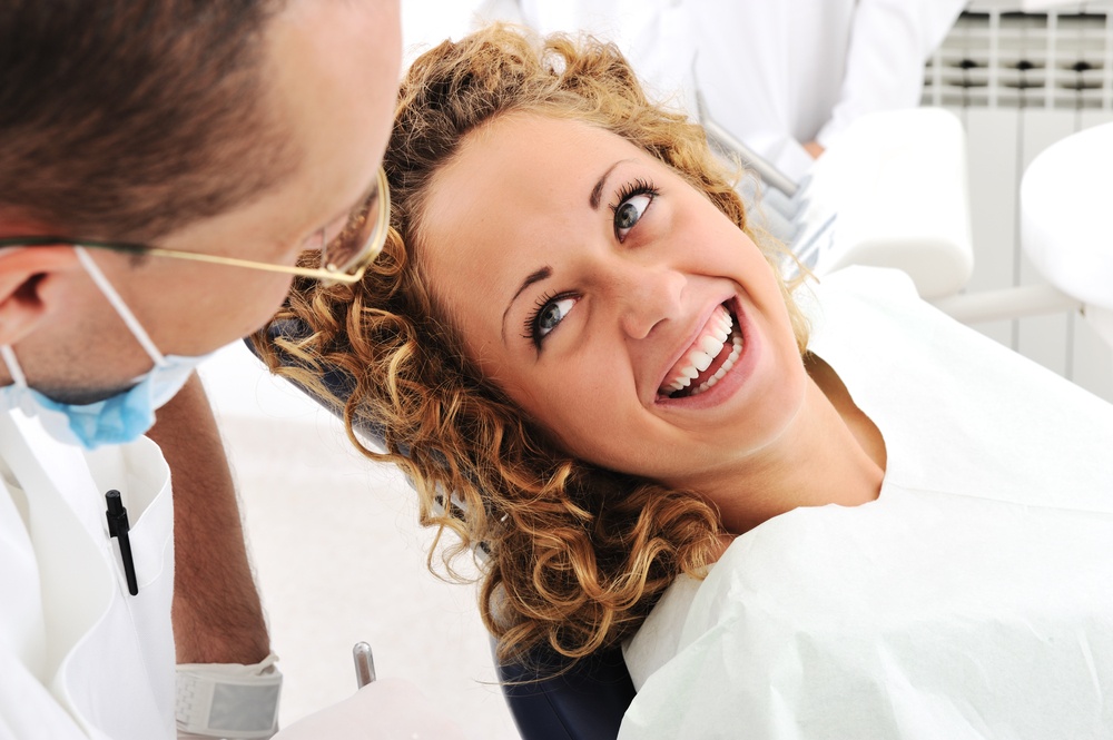 Your fear of the dentist will get better with time - Happy woman smiling at dentist