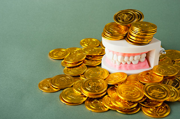 Affordable dental care - Dental teeth model and gold coins